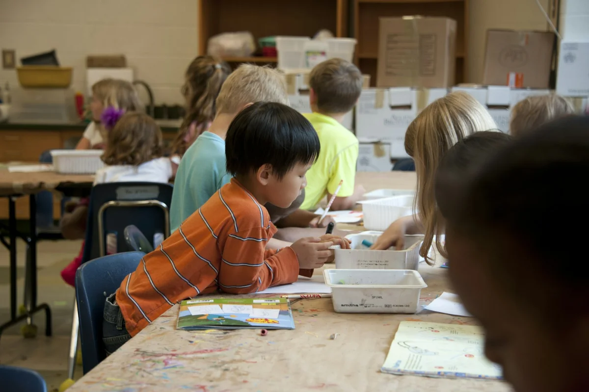 Young student drawing with crayons in an Atlanta, Georgia primary school classroom