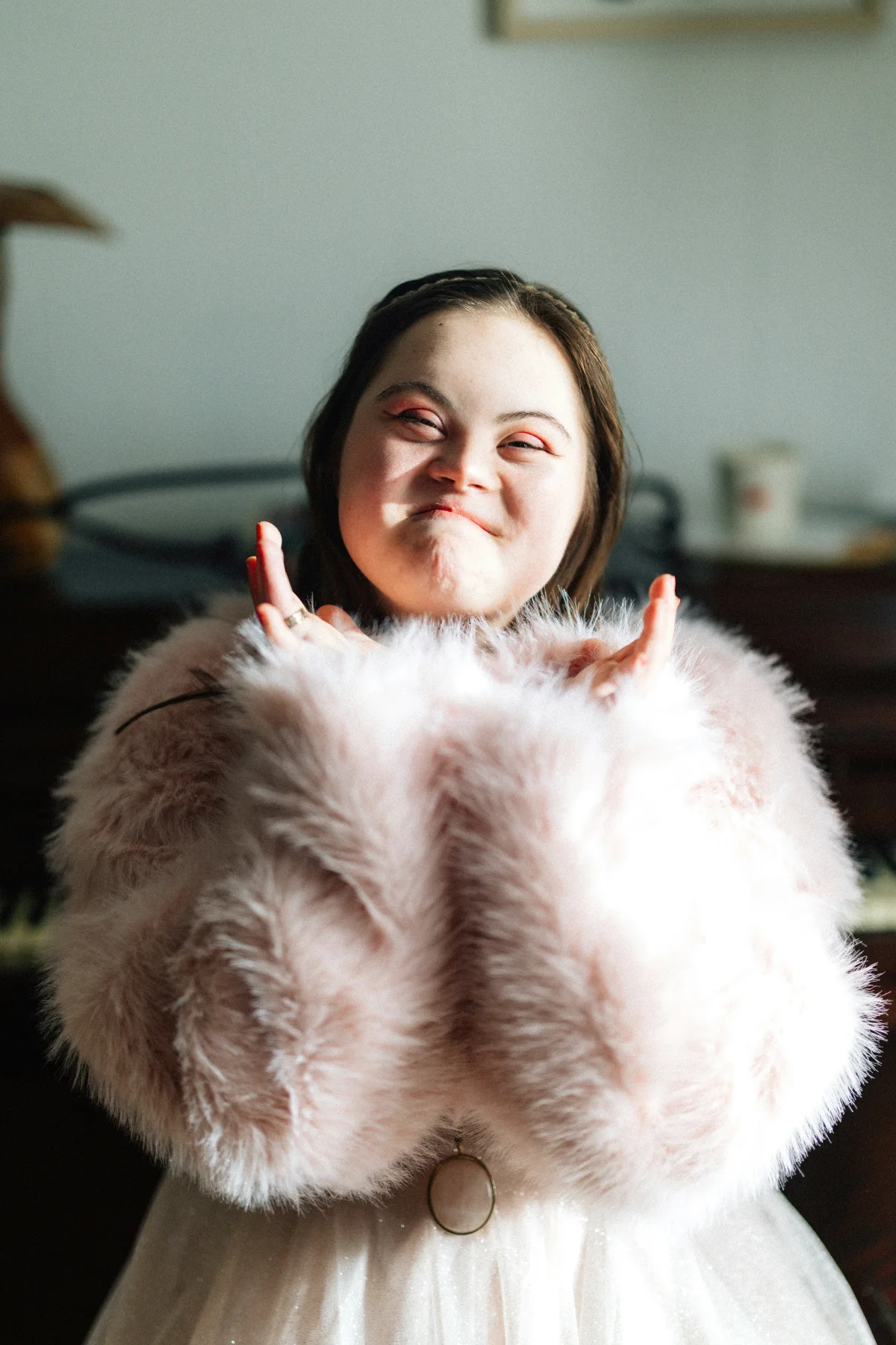 A child wearing a pink coat smiling at the camera