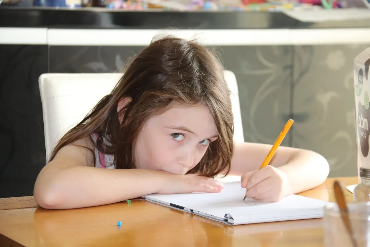 Girl concentrating while writing in a notebook