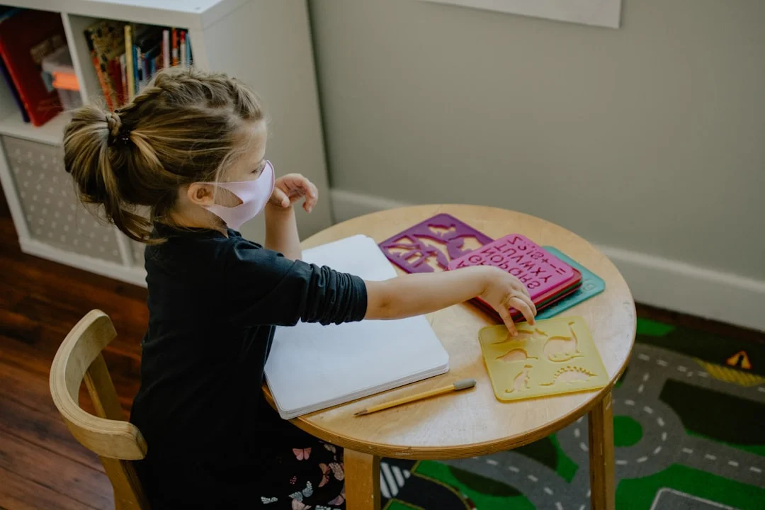 Child in classroom reaching for stencils, representing how teachers observe behavior in school settings