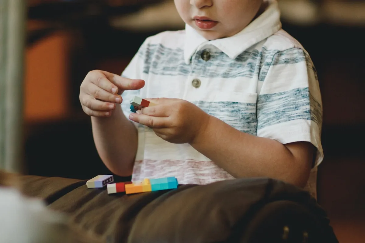 Young boy focused on building with colorful blocks