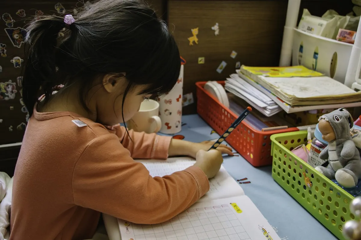 Young girl writing at school desk
