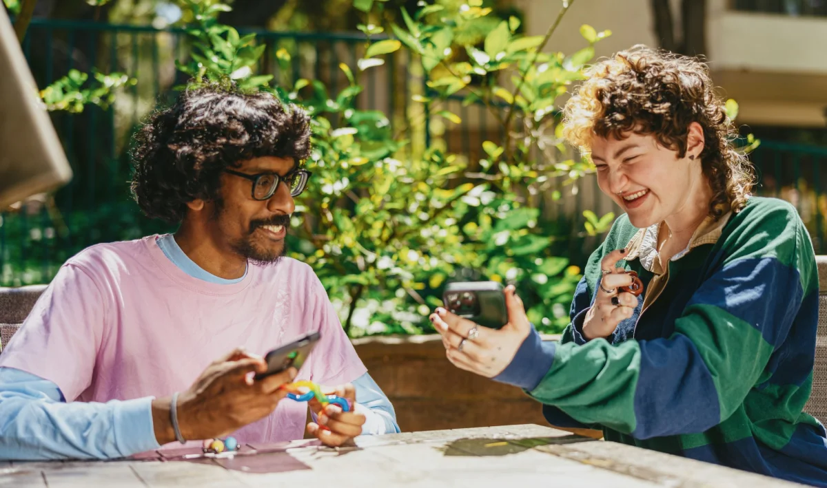 Two people collaborating outdoors, one holding a fidget toy, representing supportive special education partnerships