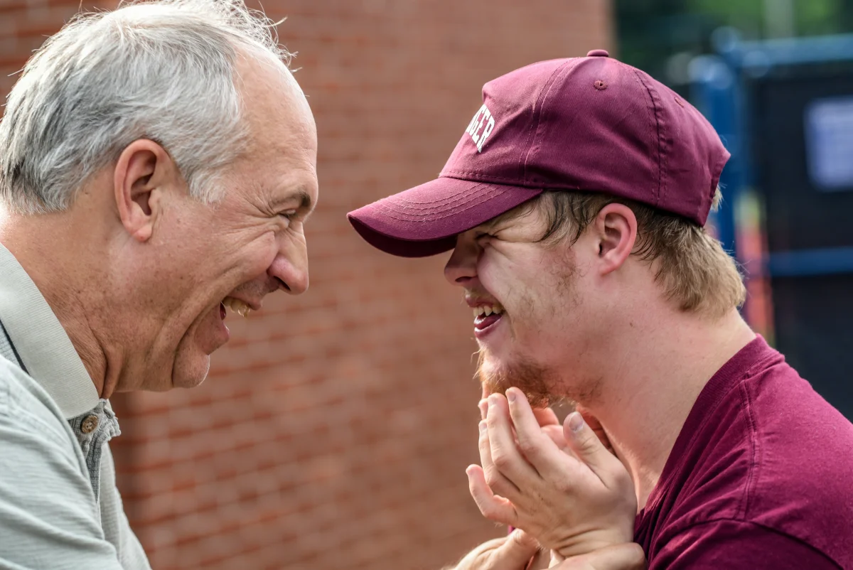 Two adults engaging in conversation and laughter, representing the human connection at the heart of therapeutic and counseling services.