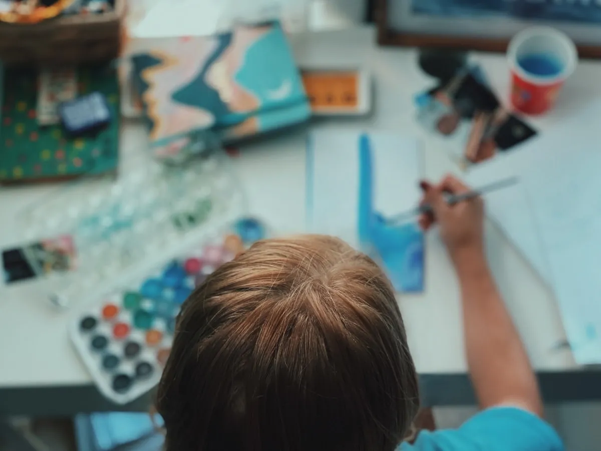 Child writing and focusing at a desk in a classroom setting