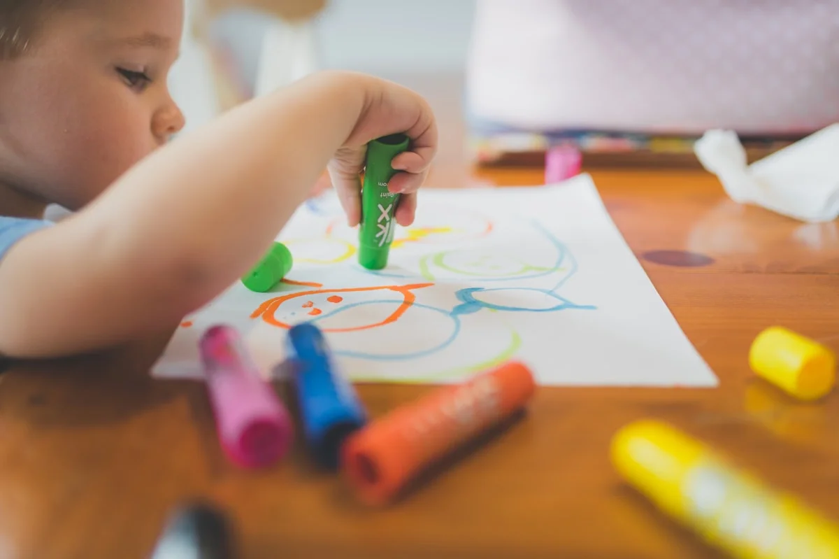 Young child engaged in a learning activity at a table, representing educational assessment and evaluation