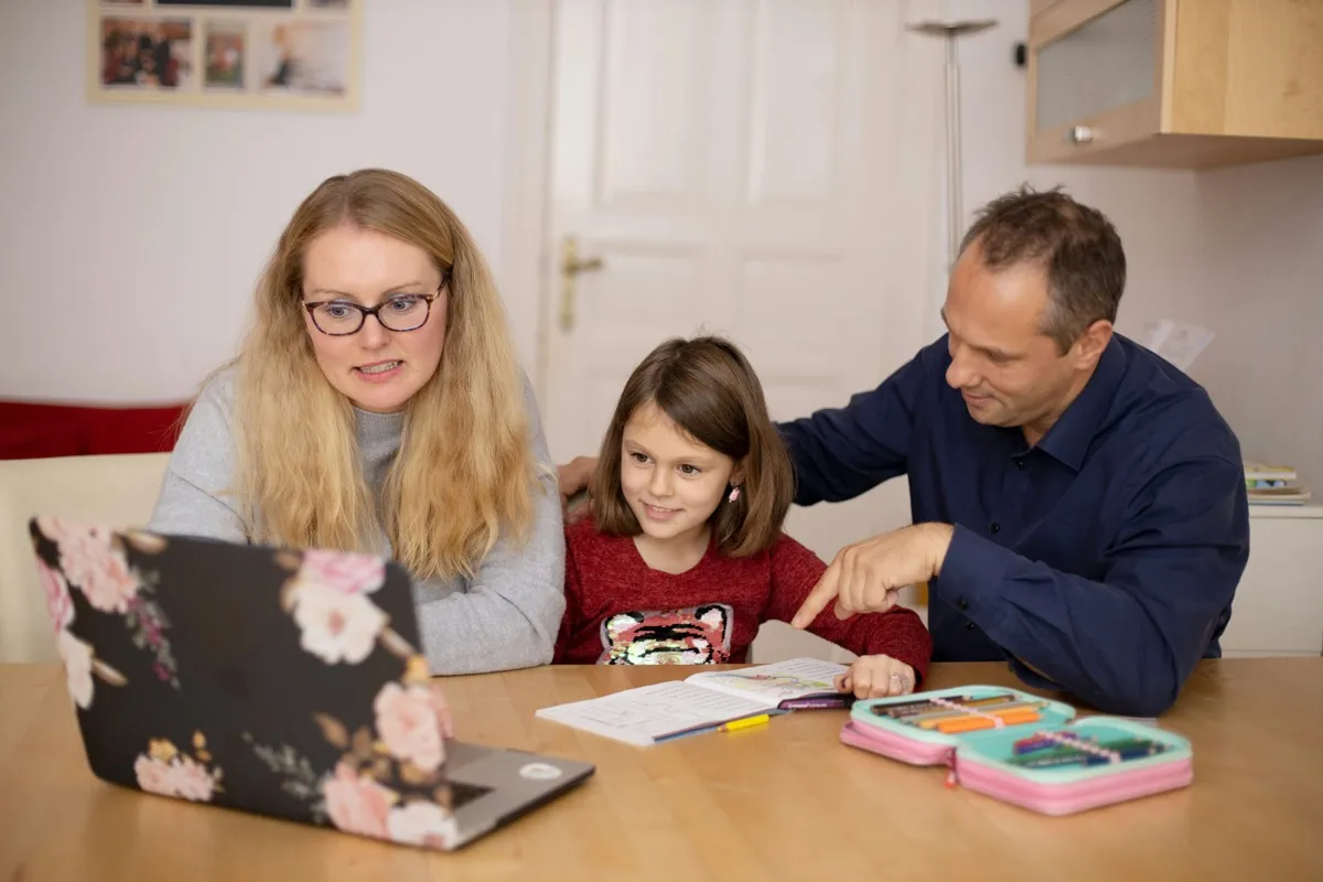 Teacher guiding children drawing at a table